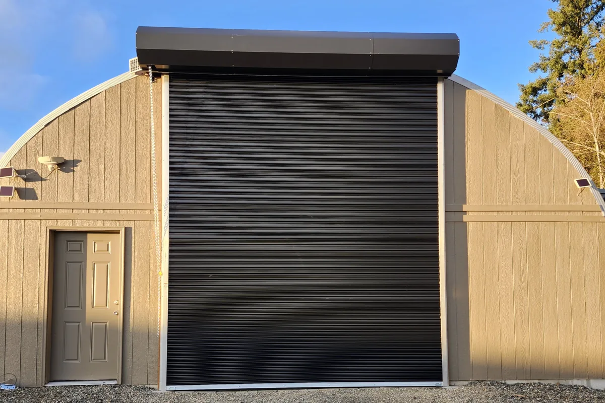 Black roll-up door on a round-roof steel building